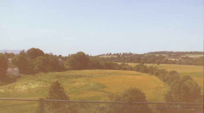 Fields near rural village as seen through train window; Ireland