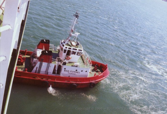 Red Funnel tugboat prepares to maneuver QE2 into Southampton harbor