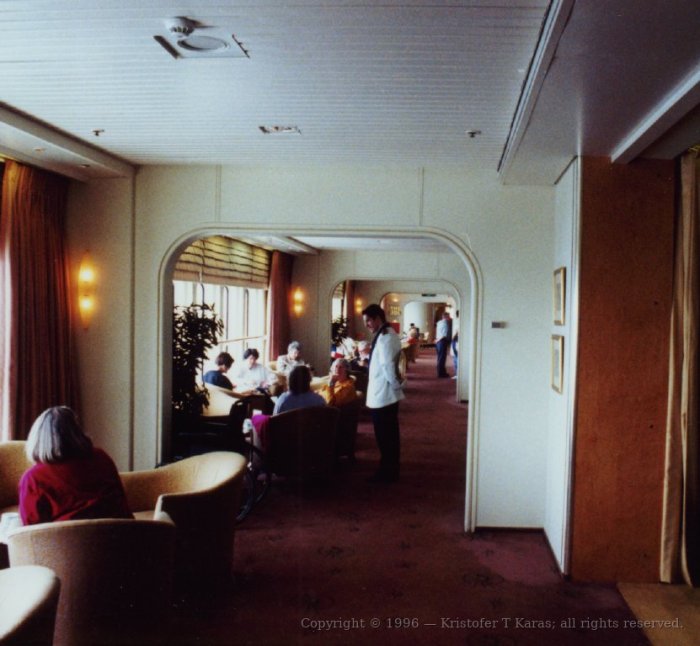Interior gangway with seated passengers aboard the QE2