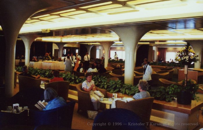 Passengers seated in one of the multi-purpose lounge areas aboard QE2