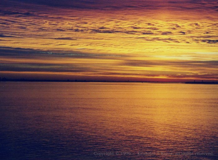 A red sky turns to gold as the sun lifts higher over New York; QE2