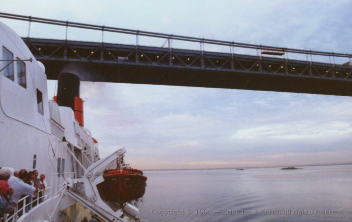 Queen Elizabeth II steams below a bridge en-route for the Hudson; New York