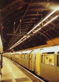 Tube train boarding passengers, with construction; London