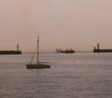 Sailboat and ferry share the waters of Dover Harbor, England