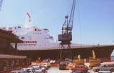 Crane poised to hoist cargo into the QE2's hold; Southampton, England
