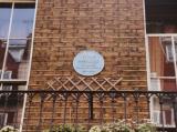 Round plaque high up on the wall showing "221b_Baker" address, London